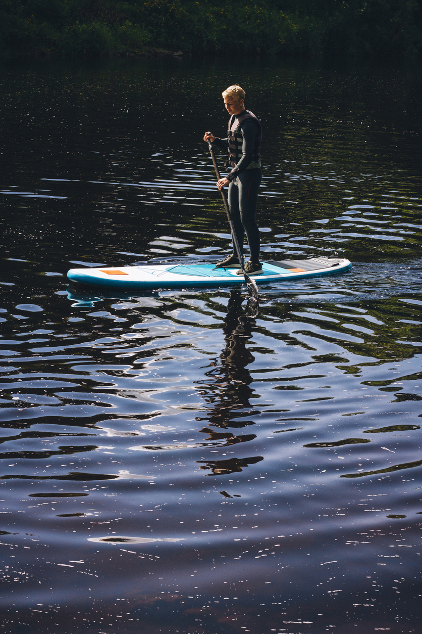 Teenager paddleboarding on Tamar lake.