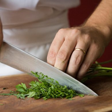 A close up of a chef chopping herbs