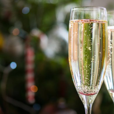 Two Champagne Flutes on Christmas Background with Xmas Tree